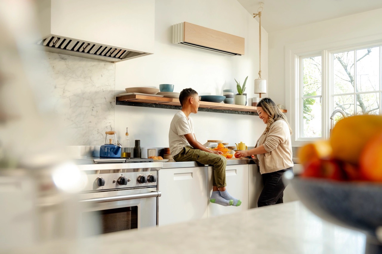 Family in a kitchen, with an unobtrusive Quilt unit mounted above the counter 