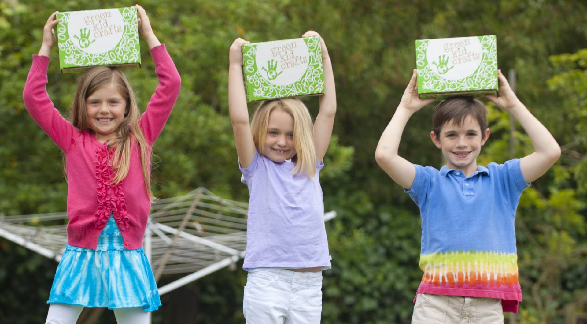 children holding up green kids boxes